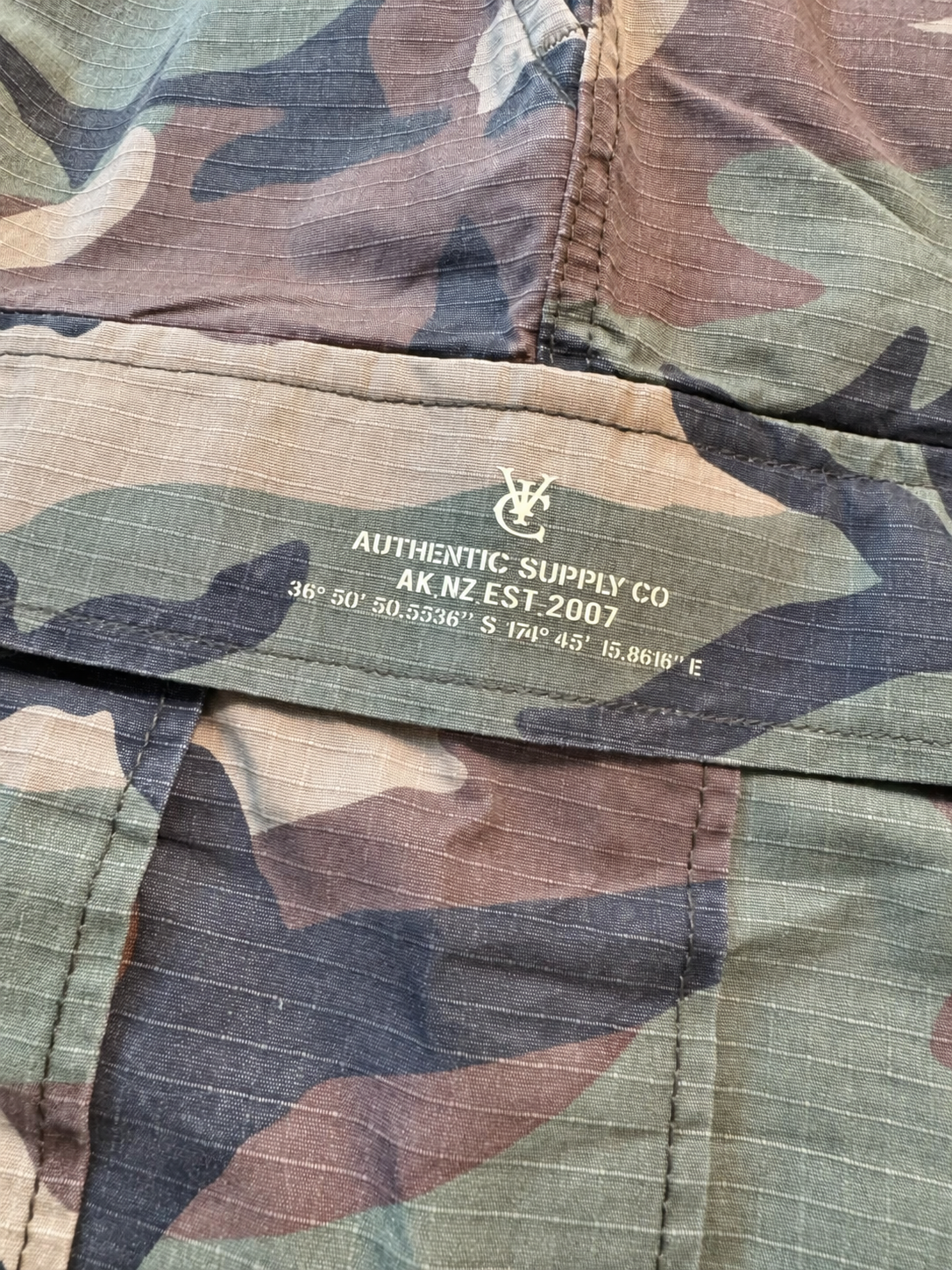 Woodland camo cargo shorts with a relaxed, below-knee fit and raw hems