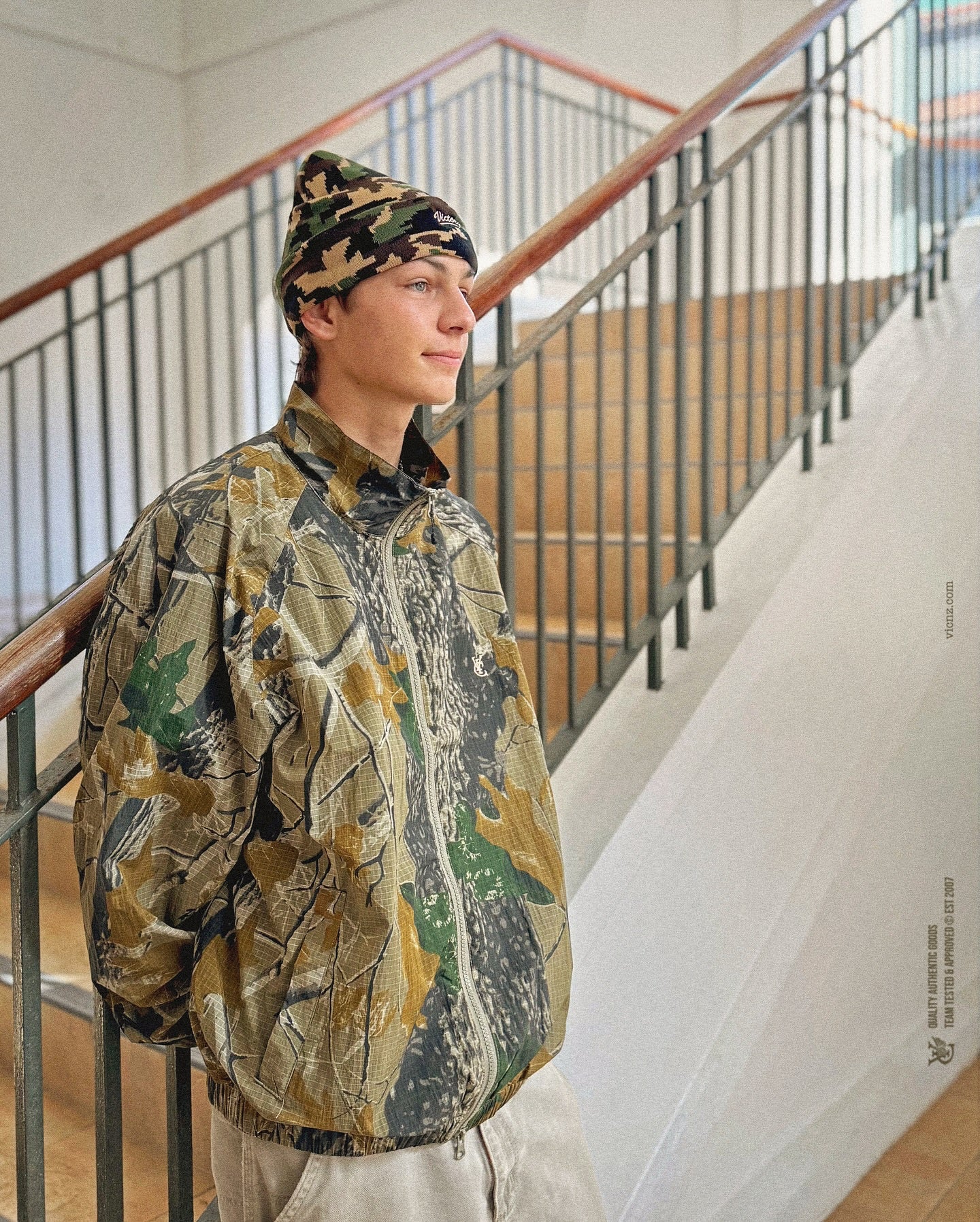 Bence in Digital Camo Beanie and VIC realtree Camo Windbreaker. Created in a lightweight, water repellent polyester fabric that dries fast and provides protection from wind and rain showers. Mesh lined for breathability, the windbreaker features our feather logo on the left chest, 2 side pockets with zip closure, back cape vents for improved airflow and moisture control and a relaxed boxy fit.