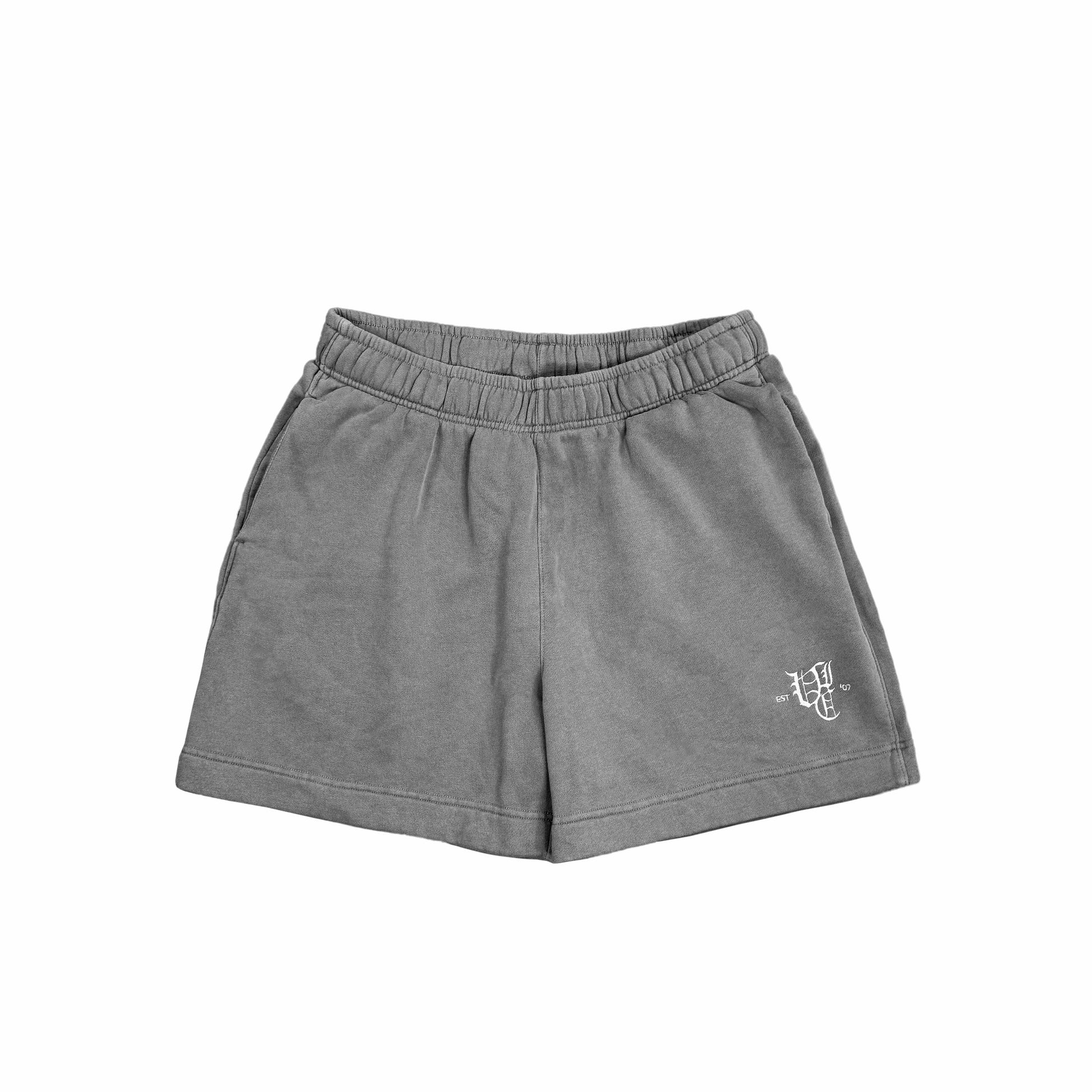 Upgrade your wardrobe with our OL' ENGLISH FADED TRACK SHORTS. Enjoy a relaxed and boxy silhouette with a mid-length, above knee fit. Made with 80% cotton and 20% recycled polyester anti-pill fleece, these shorts are both comfortable and environmentally friendly. The elastic waistband and drawstring ensure a perfect fit, while the pockets provide convenience. Complete with an embroidery logo, these shorts are a must-have for any casual outfit.