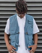 VIC Utility Vest / Inspired by vintage workwear silhouettes : Boxy fit / 100% Polyester, durable water resistant coating / Two way zip closure at front / 5 front pockets / 2 quick release buckles & side closures for layering / Hidden pocket at centre back / VIC woven flag label at front left chest pocket