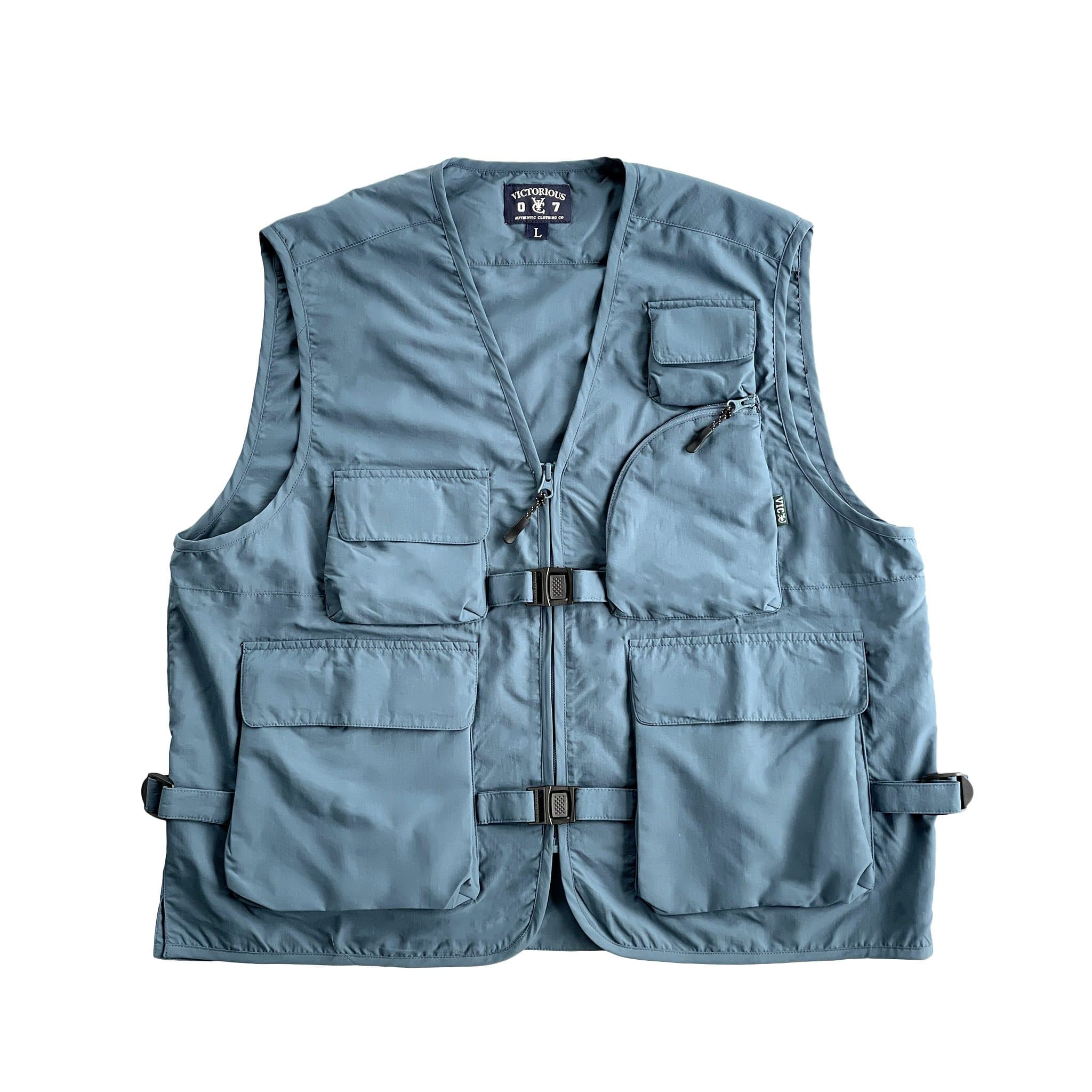 VIC Utility Vest / Inspired by vintage workwear silhouettes : Boxy fit / 100% Polyester, durable water resistant coating / Two way zip closure at front / 5 front pockets / 2 quick release buckles & side closures for layering / Hidden pocket at centre back / VIC woven flag label at front left chest pocket 